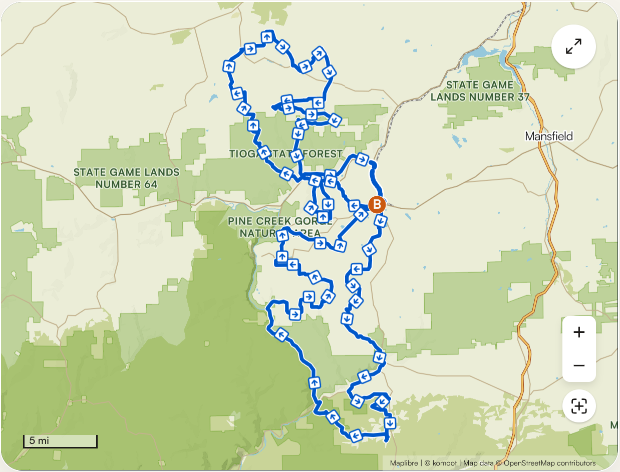 Map showing a trail within Tioga State Forest, including Pine Creek Gorge area, with multiple trail segments marked by arrows and a starting point labeled B. Surrounding areas include state game lands and nearby towns like Mansfield.