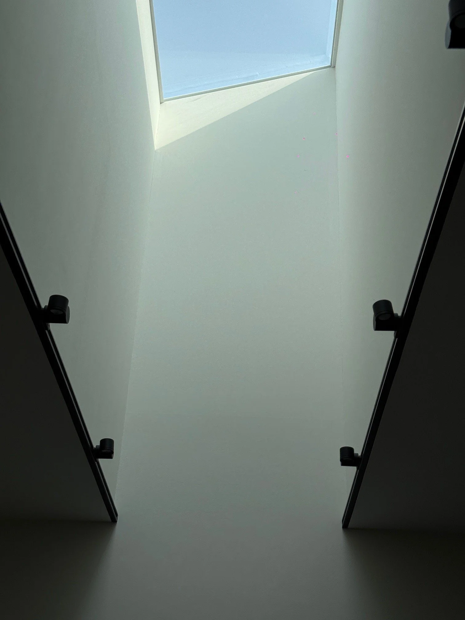 Looking up at a skylight ceiling with sunlight coming through.