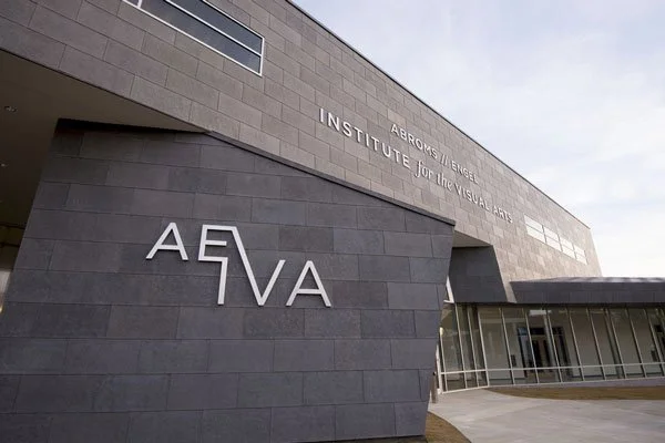 Exterior view of the AEIVA at the University of Alabama at Birmingham building with a modern gray facade and prominent signage.