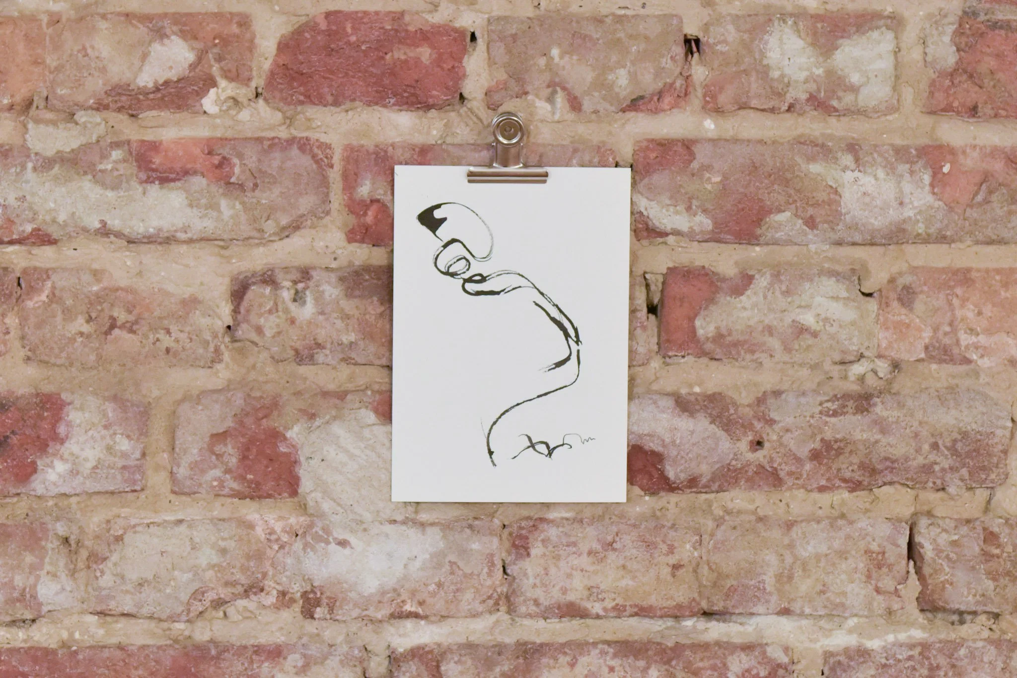 A minimalist black-and-white line drawing of a hand holding a cigarette, clipped to a white piece of paper with a metal clip, against a red brick wall background.