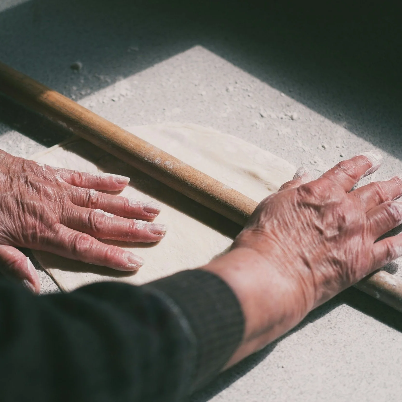 Experienced hands rolling dough—a quiet moment of tradition in retreat cooking
