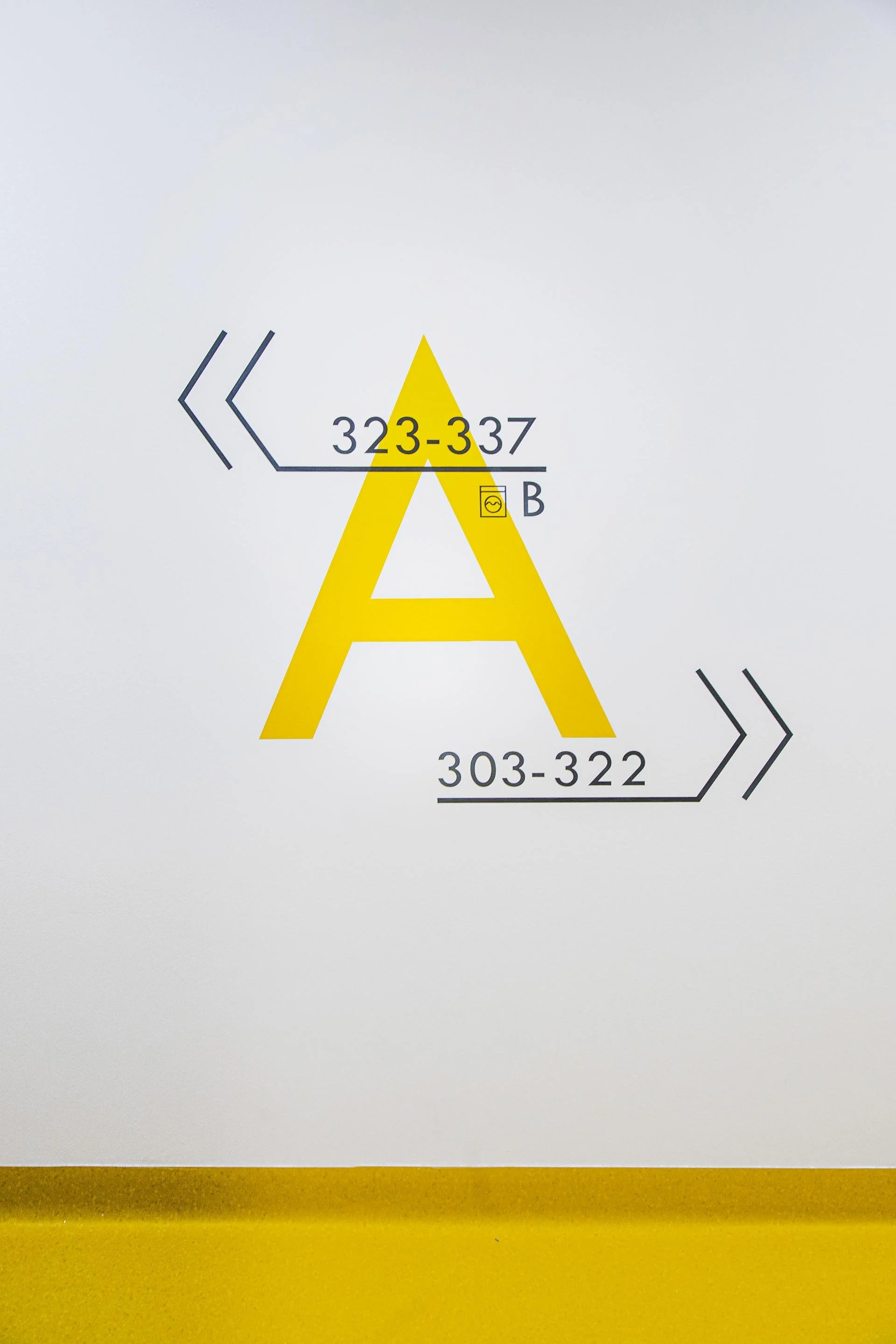 Graphic with a large yellow letter 'A' at the center, surrounded by black arrows and numbers indicating directions and ranges, likely related to directional or instructional signage.