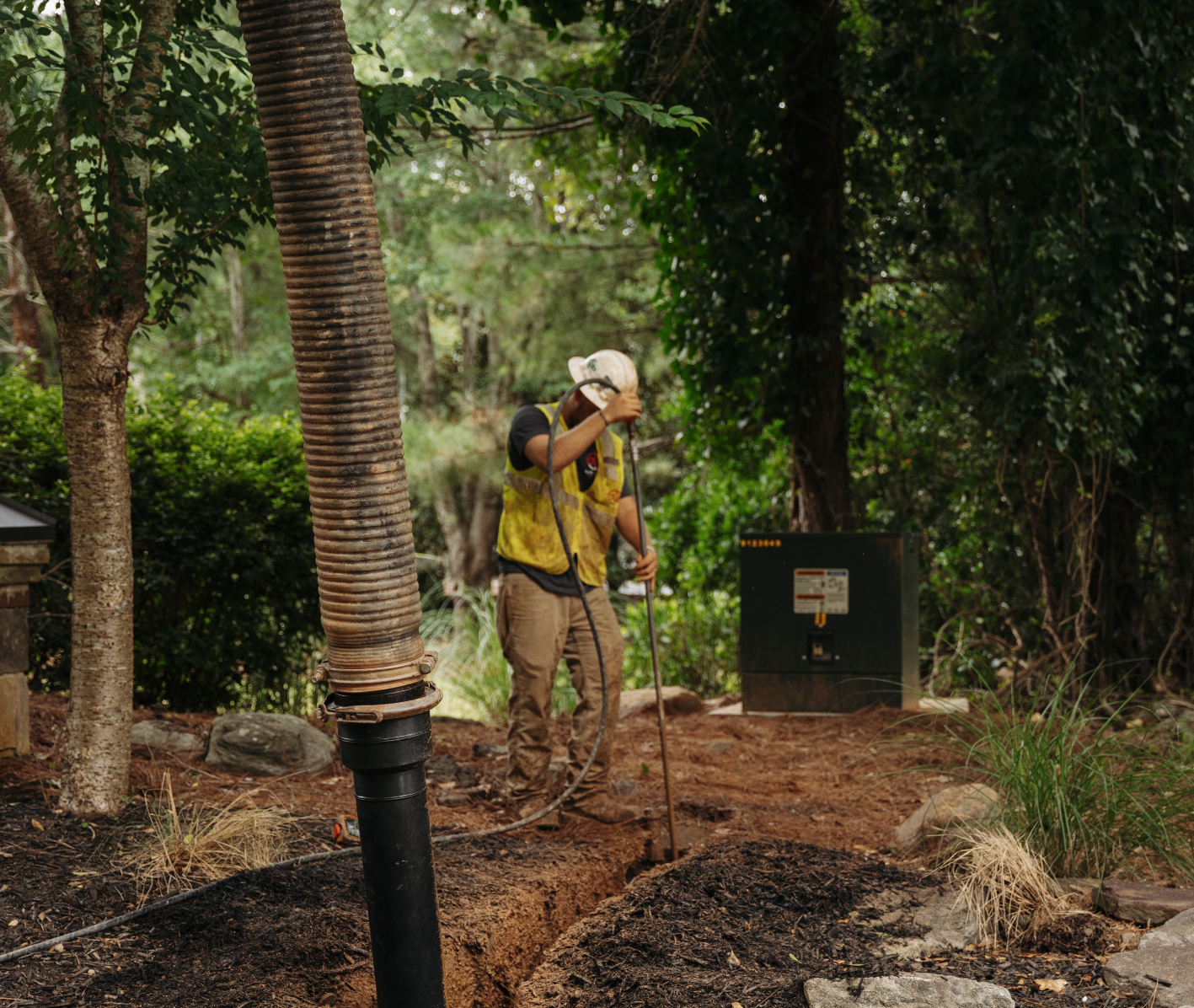 Workers using vacuum excavation equipment on roadside