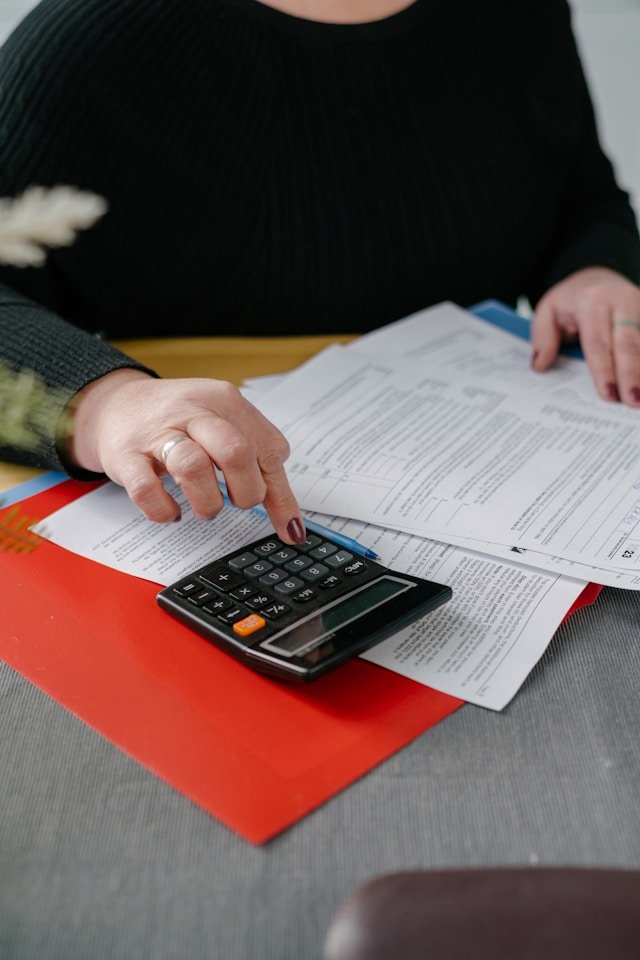 Person using a calculator with documents on a table