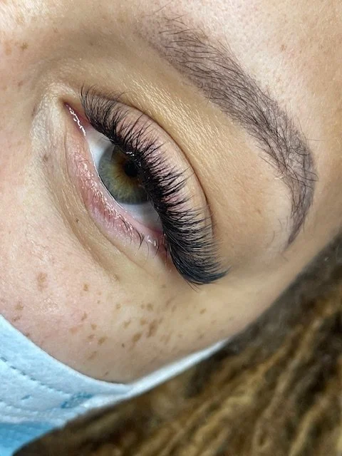 Hybrid lash extensions blend classic and volume techniques for soft texture, added fullness, and a naturally wispy finish.