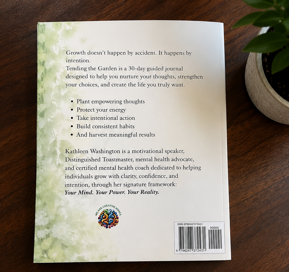 Back cover of a guided journal with a green leafy design on the left side, placed on a wooden surface. There is a potted plant on the right side.