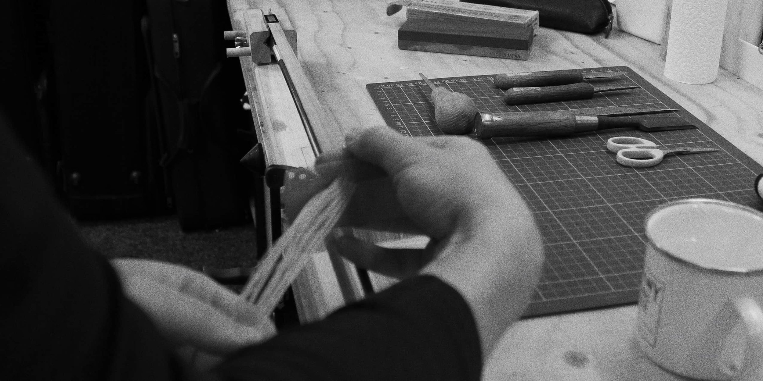 A person checking the hair on a freshly rehaired violin bow