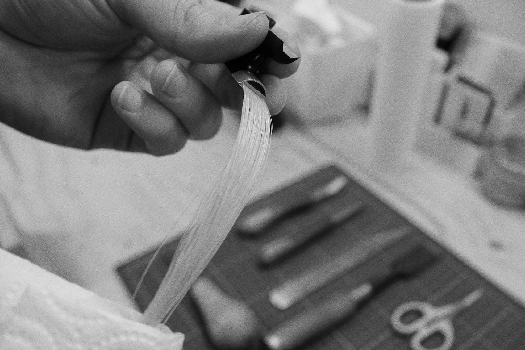 A hand holding violin bow frog during the rehair process