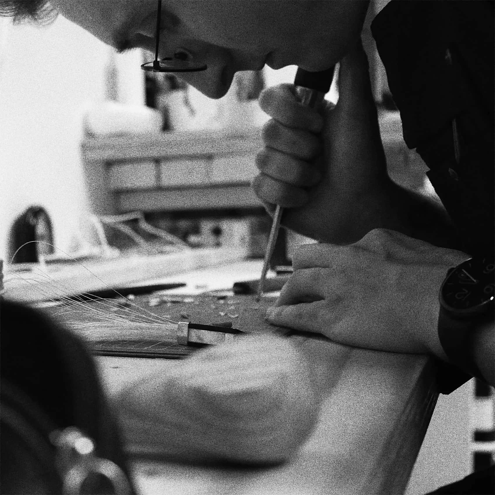 A close up of a person cutting a wedge for a bow rehair