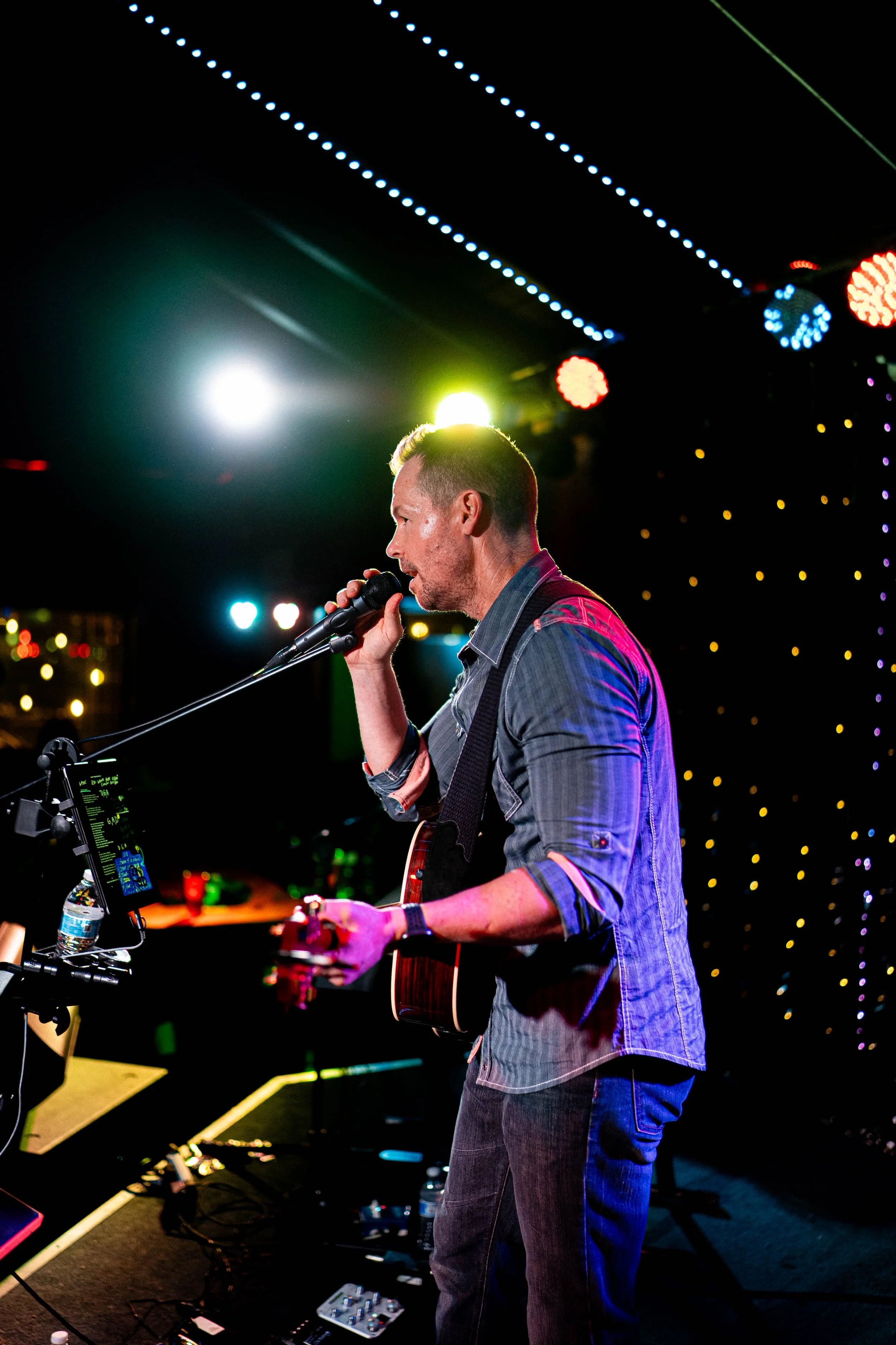 Valley Video conference, event, and concert video production services. Musician performing on stage with a guitar at night, colorful lights in the background.