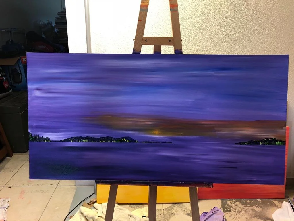 Gemälde einer Landschaft mit violettem Himmel und Wasser, auf einer Staffelei im Raum.