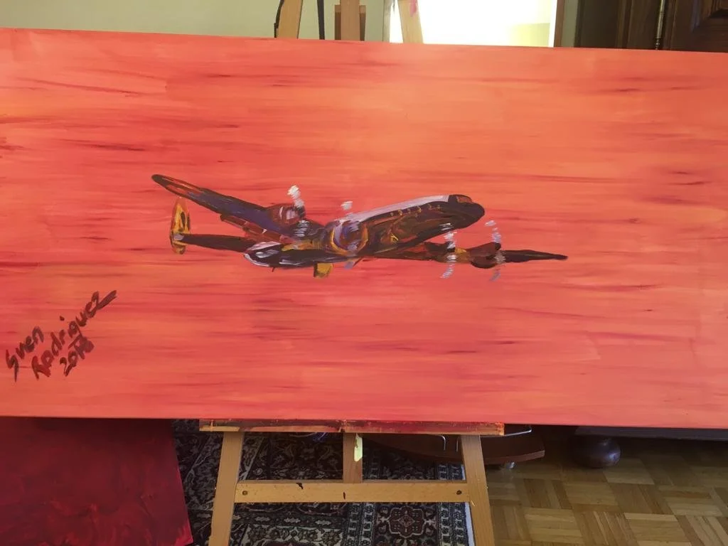 Gemälde eines Flugzeugs auf einem roten Hintergrund auf einer Staffelei
