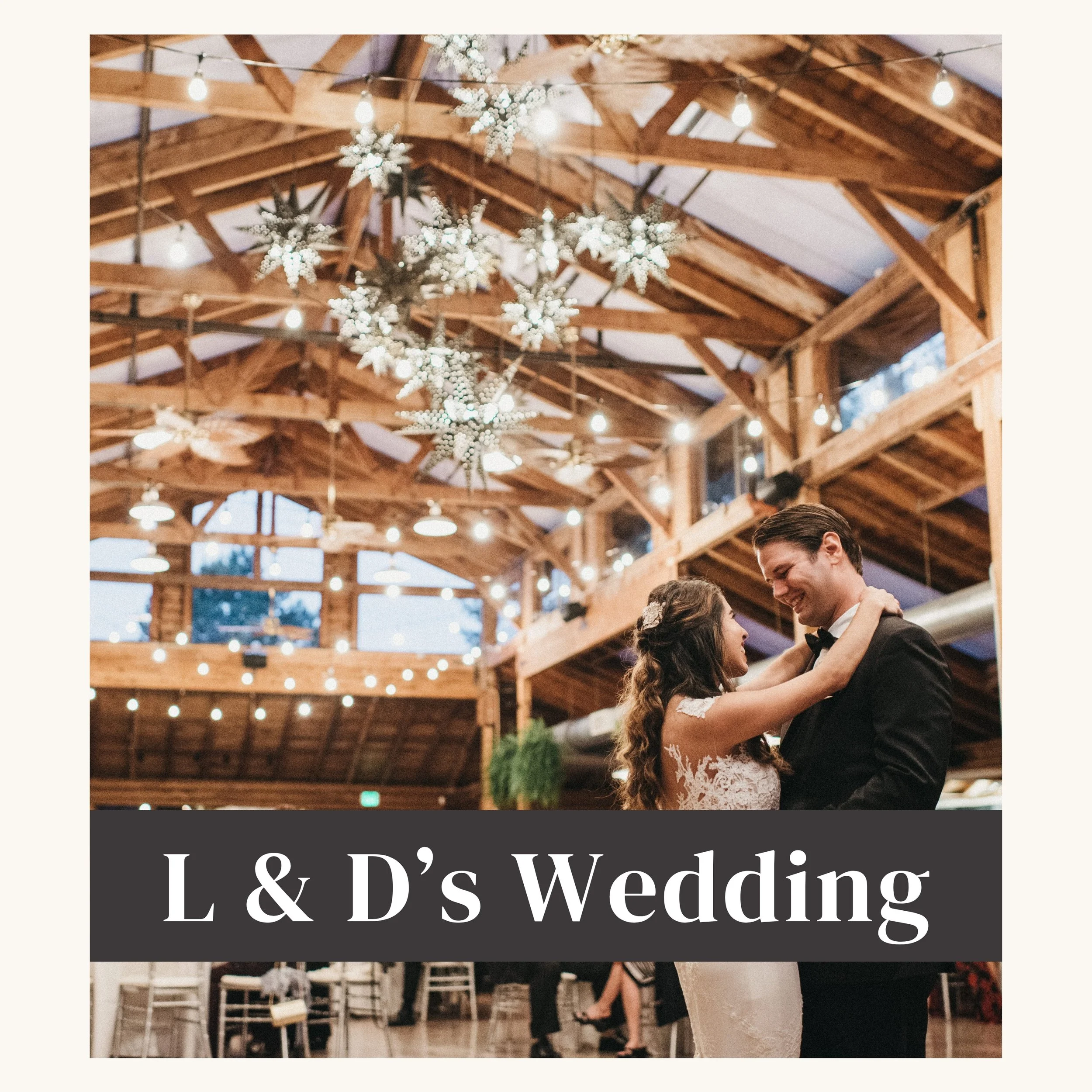 A bride and groom dance together at their wedding reception in a rustic wooden venue decorated with hanging snowflake ornaments and string lights.