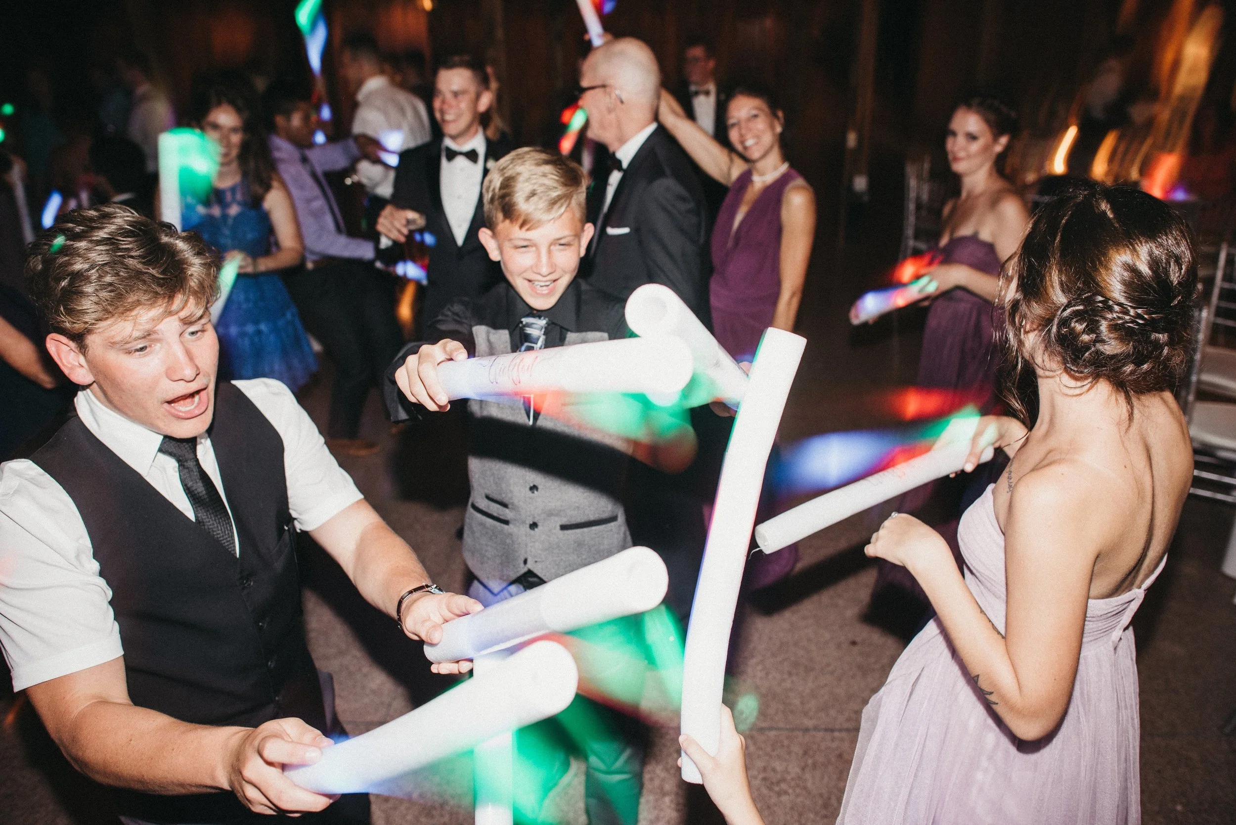 People dancing and playing with glow sticks at a celebration or party.