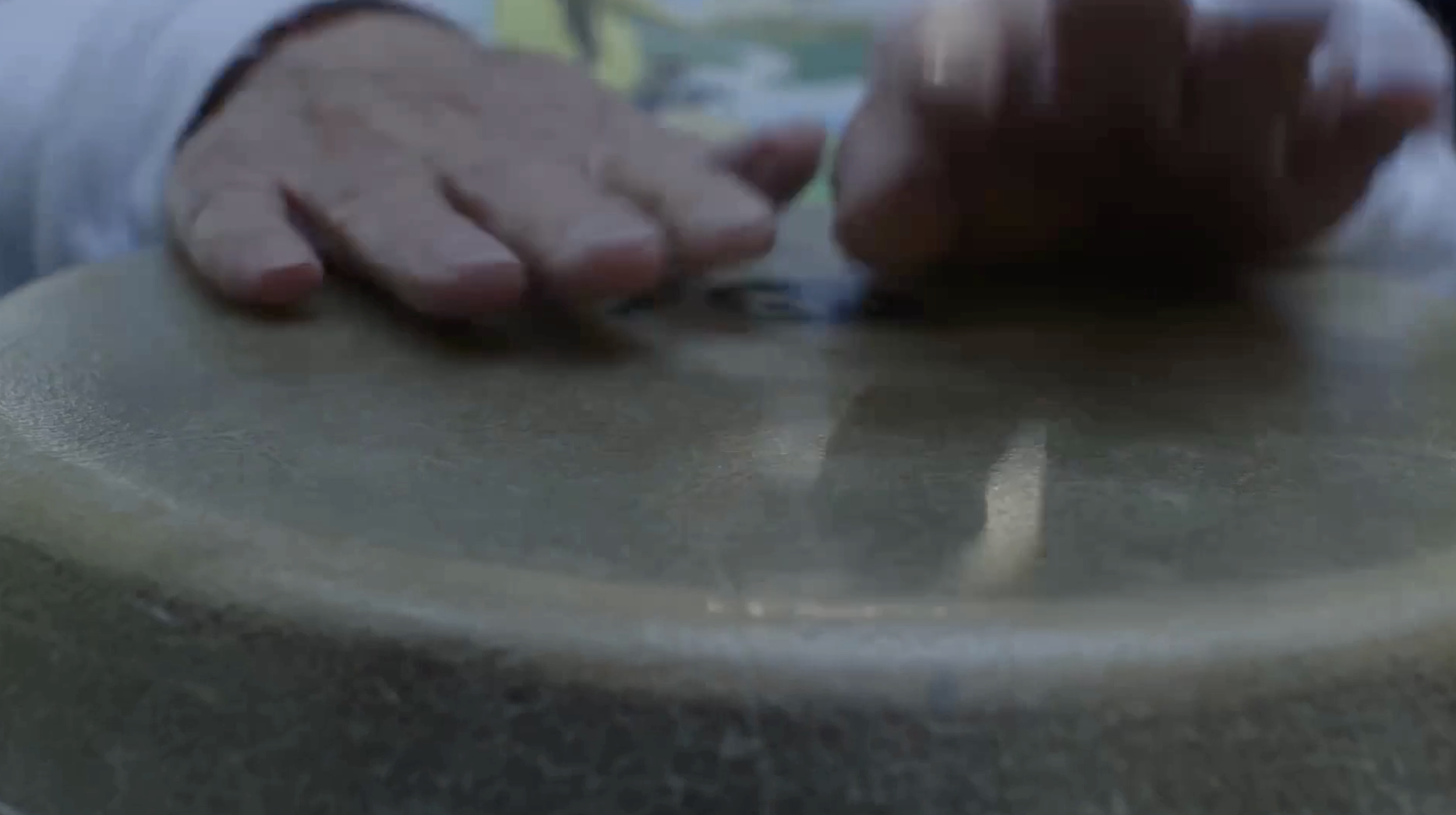 Close-up of a person's hands playing a conga drum.
