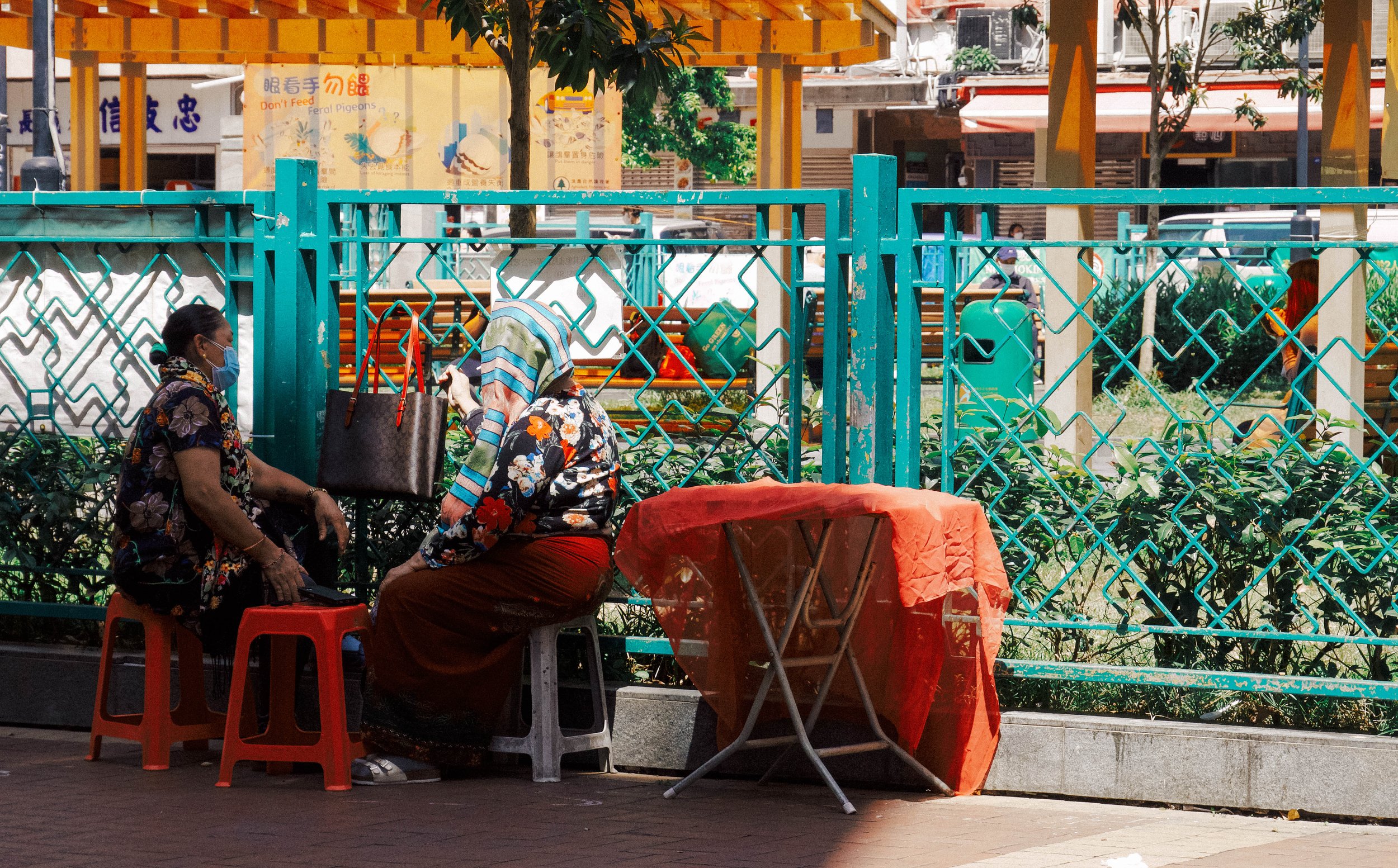Two domestic helpers chat during a break. Yau Ma Tei.