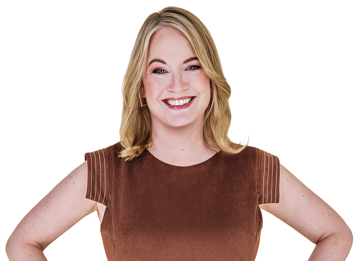 A smiling woman with blonde hair wearing a sleeveless brown top and gold hoop earrings.