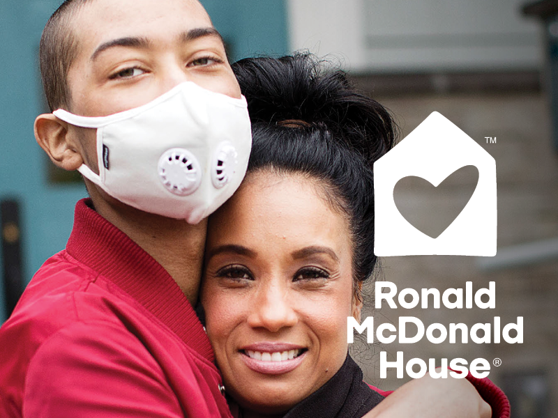 A woman and a young man wearing a face mask and hugging, with a logo and text for Ronald McDonald House.