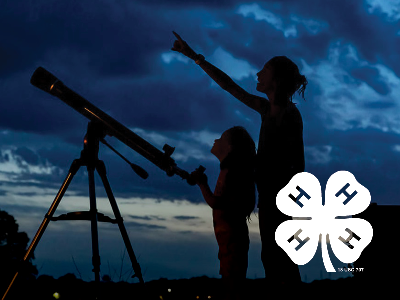 Silhouette of a woman and a girl looking through a telescope at dusk with a cloudy sky.