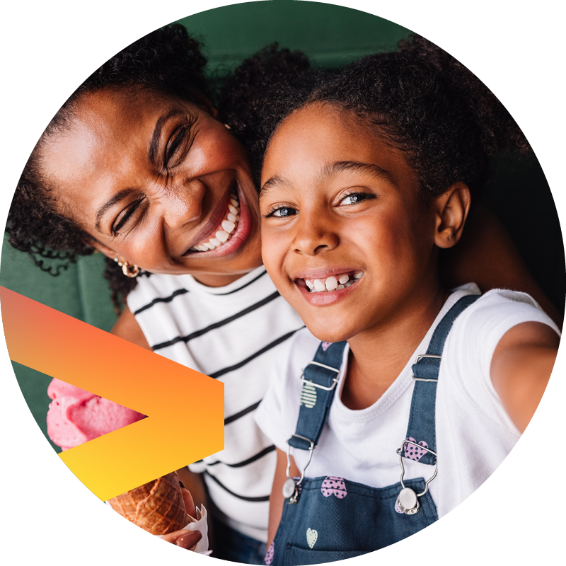 Smiling woman and girl taking a selfie, girl holding an ice cream cone.