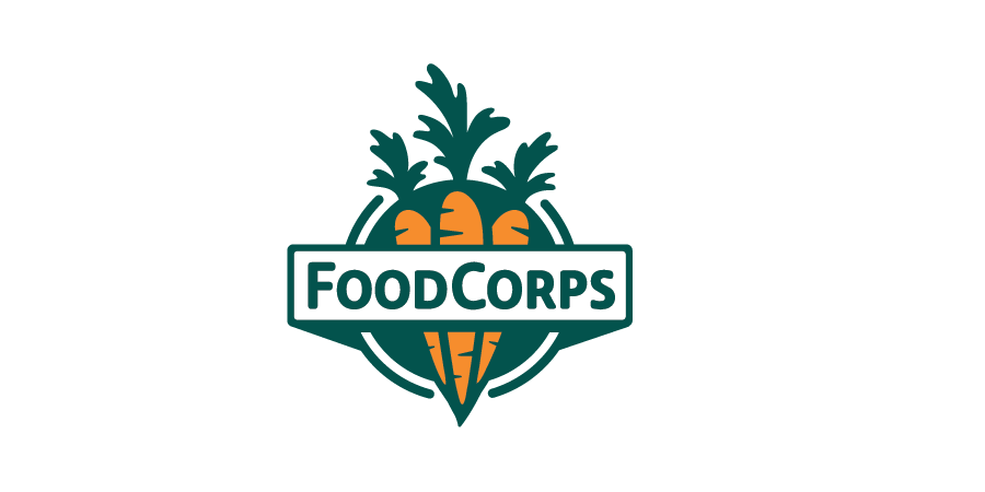 Logo of FoodCorps featuring an orange carrot with green leaves and a fork, with the text 'FOODCORPS' across the carrot in green letters.