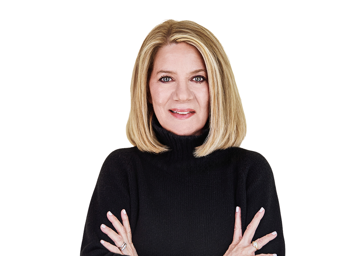 A woman with shoulder-length blonde hair wearing a black turtleneck sweater, crossing her arms, smiling, against a background with horizontal blue, beige, and brown stripes.