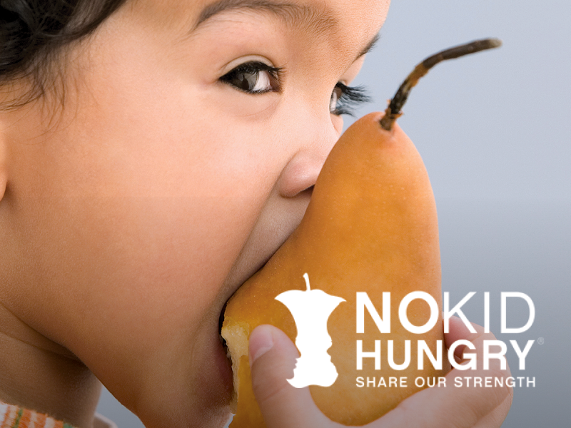 Child about to bite into a pear, with the 'Nokid Hungry' logo and slogan 'Share Our Strength' in the lower right corner.