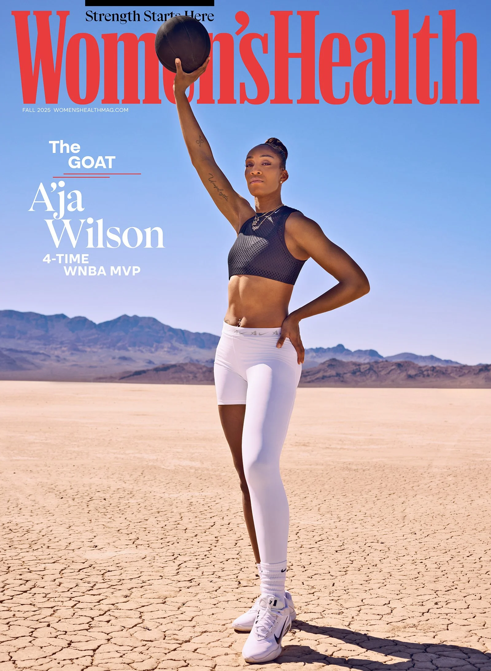 A woman in athletic wear holding a basketball in a desert landscape with mountains in the background on the cover of Women's Health magazine.