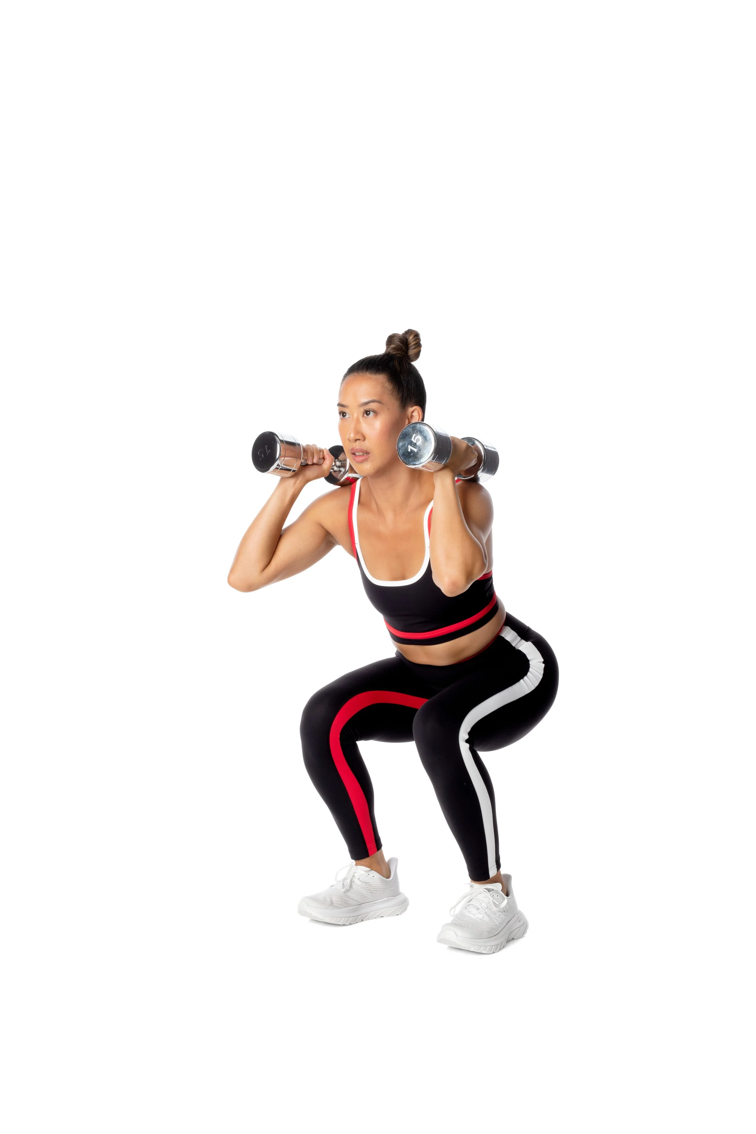 A woman exercises with dumbbells on her shoulders.