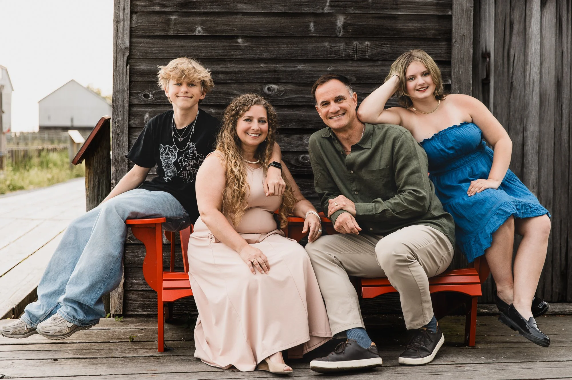 Family sitting, smiling, looking at camera at historic Britannia Shipyards, Richmond, BC.