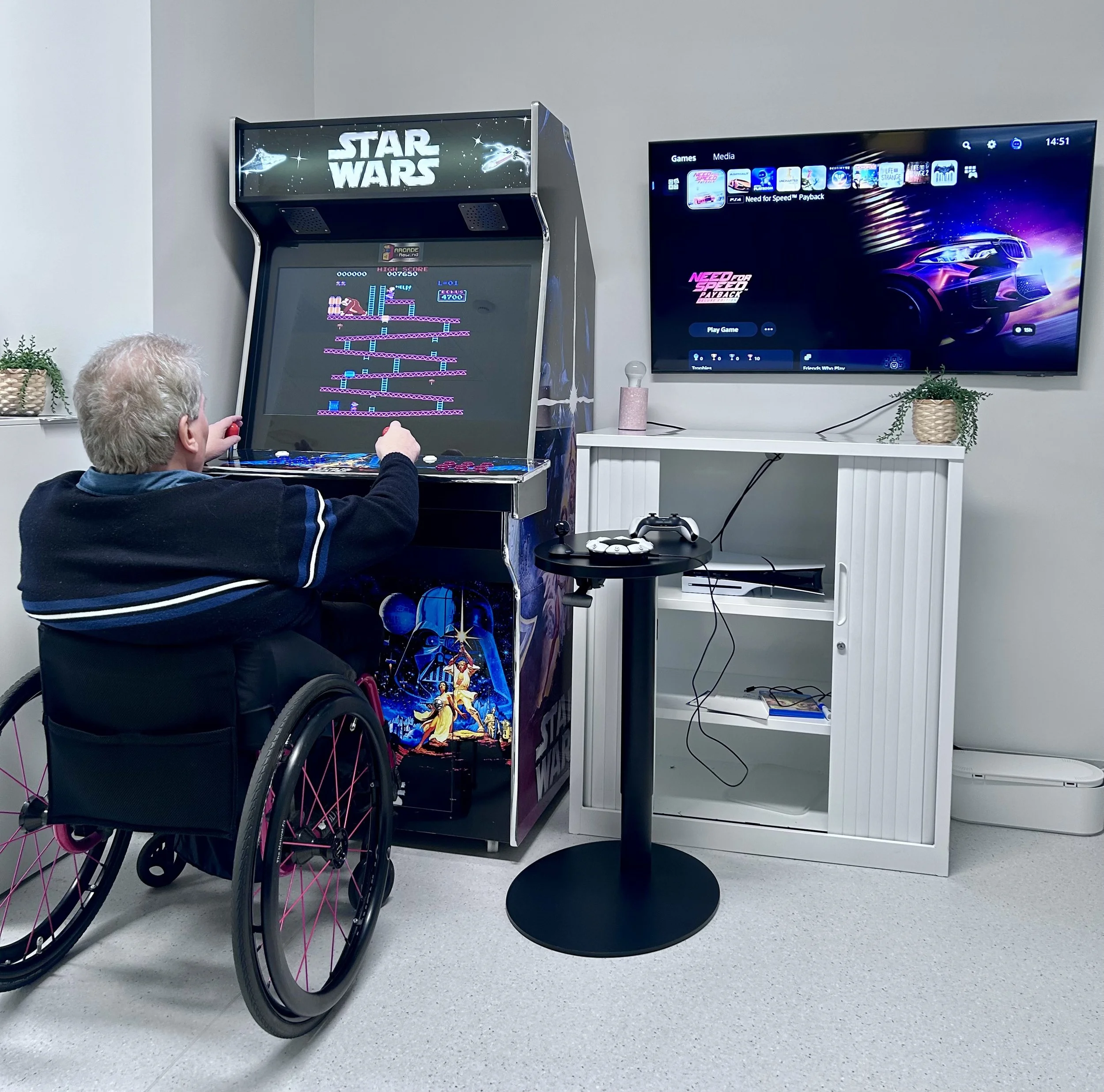 Estara Volunteer Paul Griffin using the arcade gaming machine