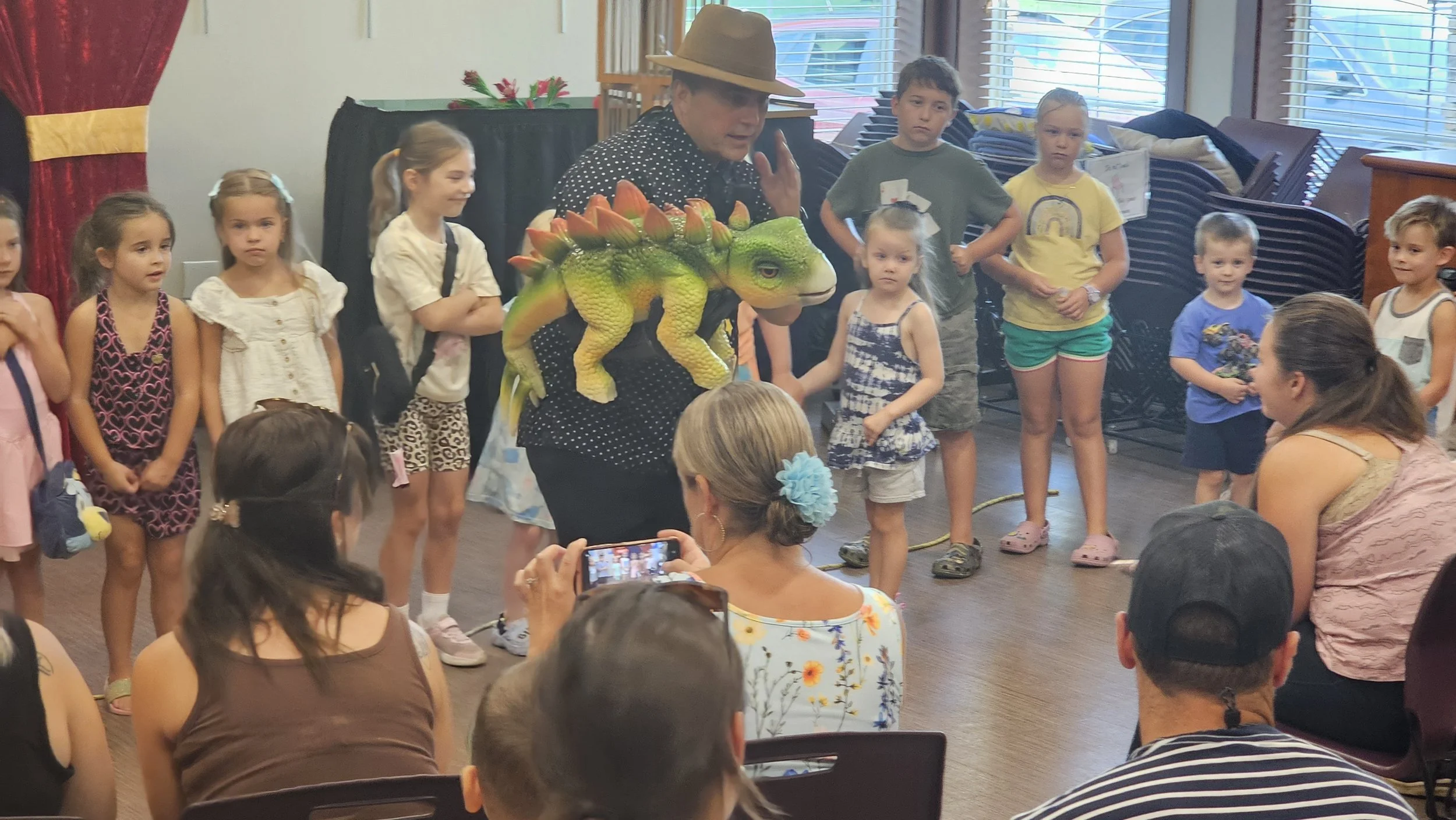 Audience is enthralled with dinosaur puppets at Magic Fred show