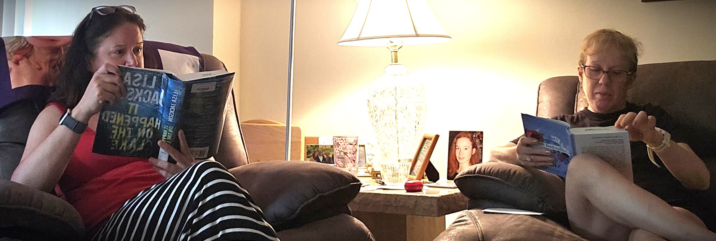 Photo of two ladies reading in a living room, preparing for book club