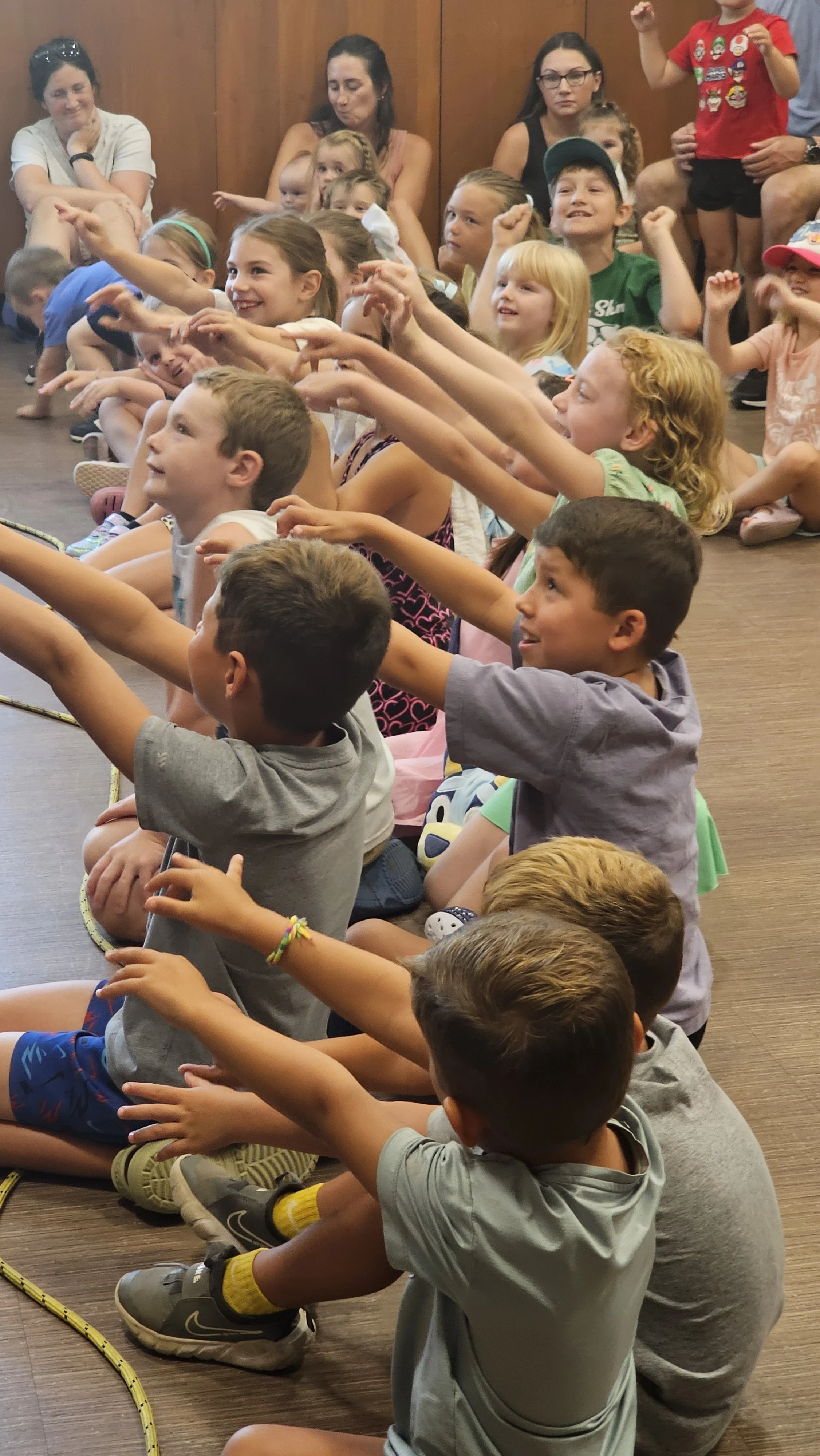 Kids wave their arms at Magic Fred show