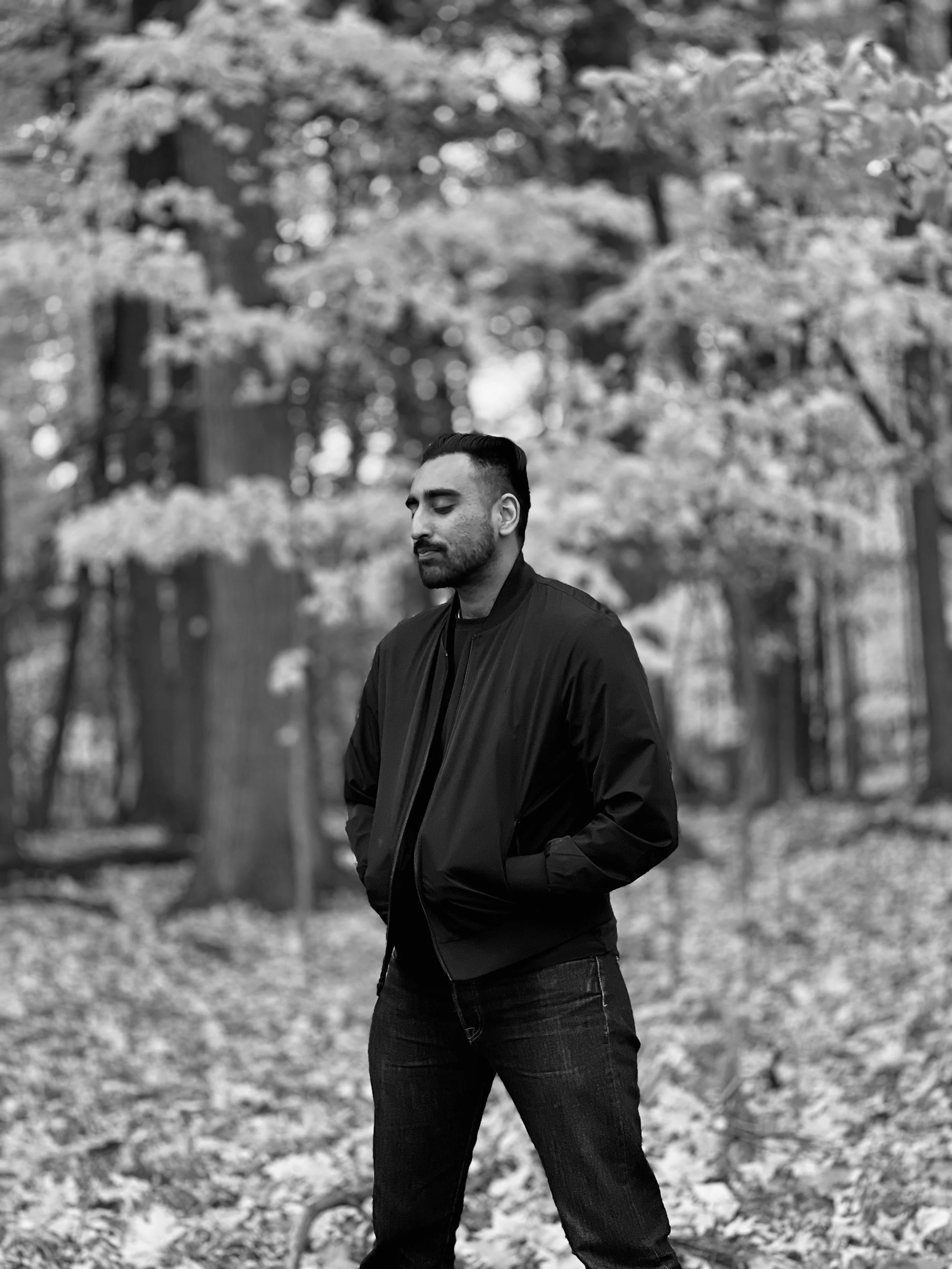 rj deol standing in the woods with eyes closed looking pensive