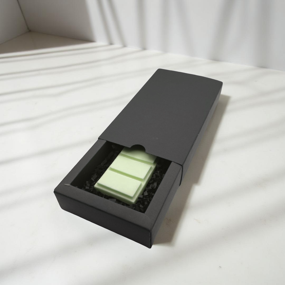 A black box containing three pieces of white chocolate.