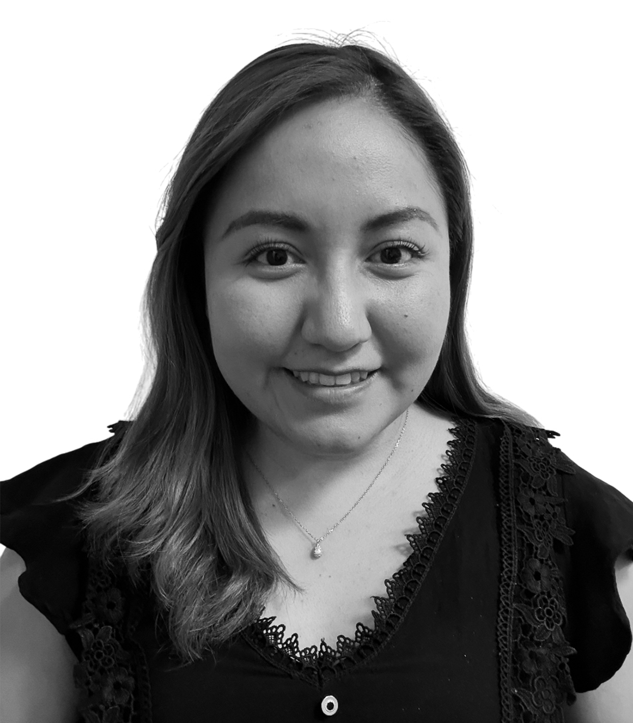 A smiling woman with shoulder-length hair wearing a necklace and a black top with lace details, in black and white.