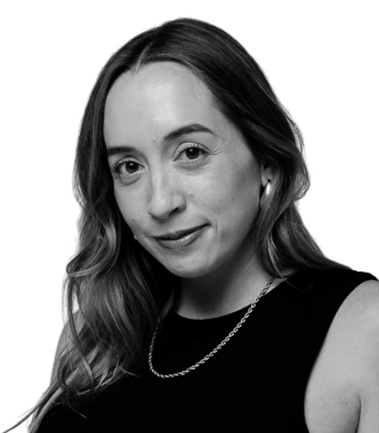 Black and white portrait of a woman with long wavy hair, wearing a sleeveless top, a chain necklace, and hoop earrings, smiling slightly and looking at the camera.