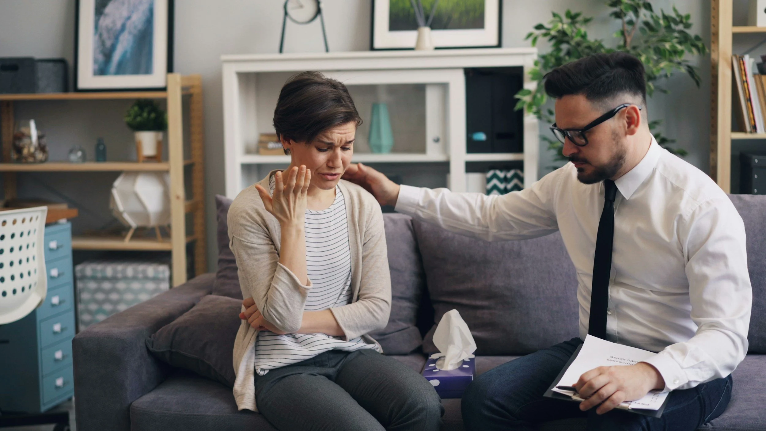 Couple in therapy room with therapist, engaged in couples therapy session supporting deeper relationship understanding
