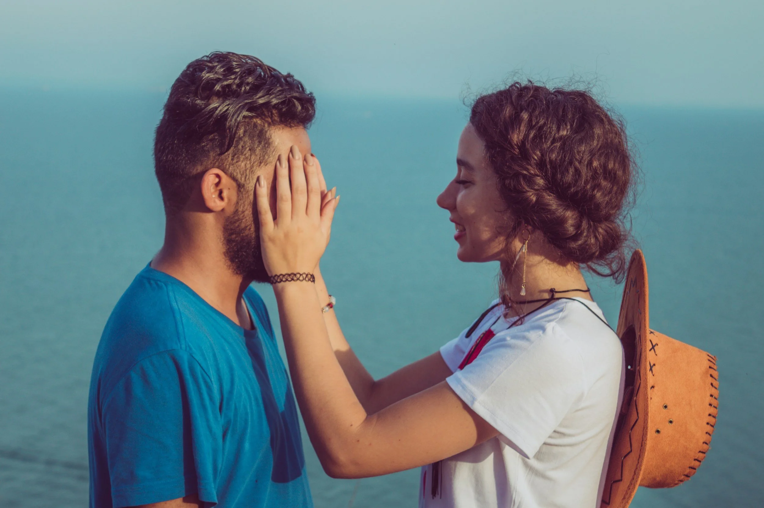 Woman gently touching her partner’s face as they stand close together, sharing a calm and connected moment after they understand their relationship patterns