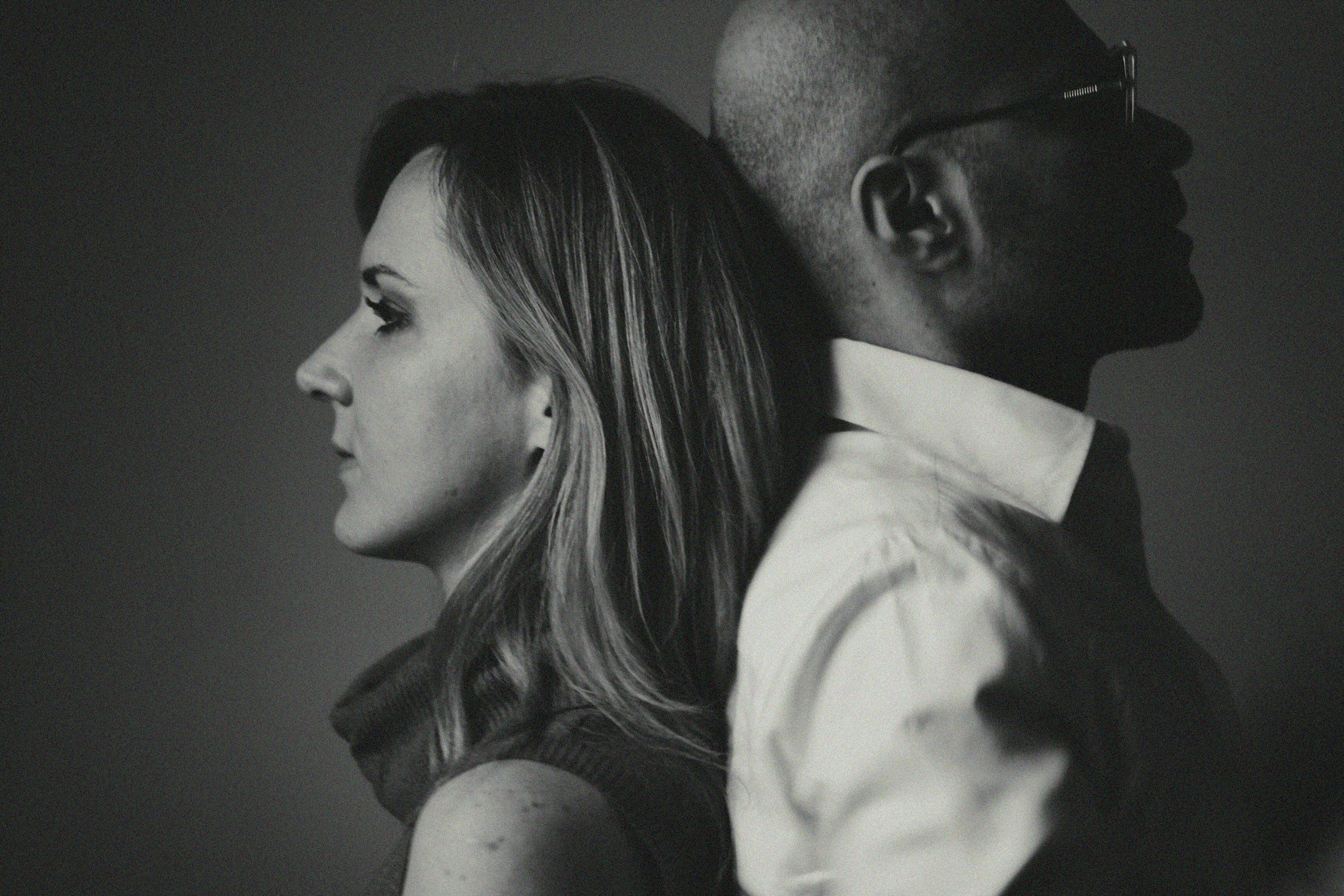 Couple standing back to back reflecting emotional disconnection and repeating relationship patterns in couples therapy