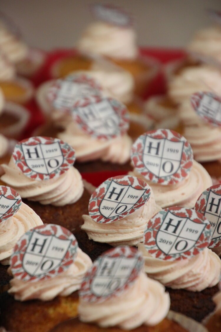 Cupcakes with swirl frosting and decorative toppers featuring a shield design.