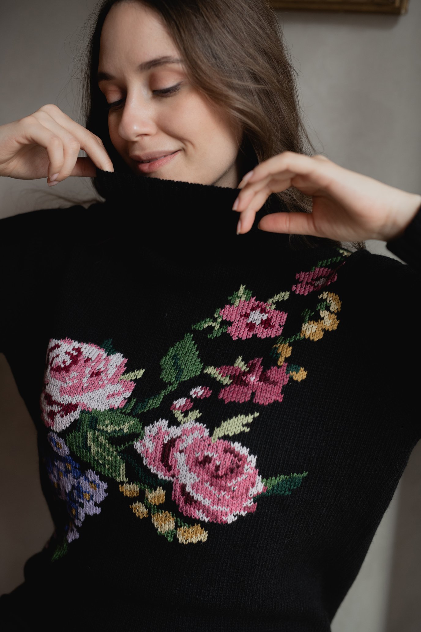 Donna con maglione nero decorato con fiori ricamati colorati