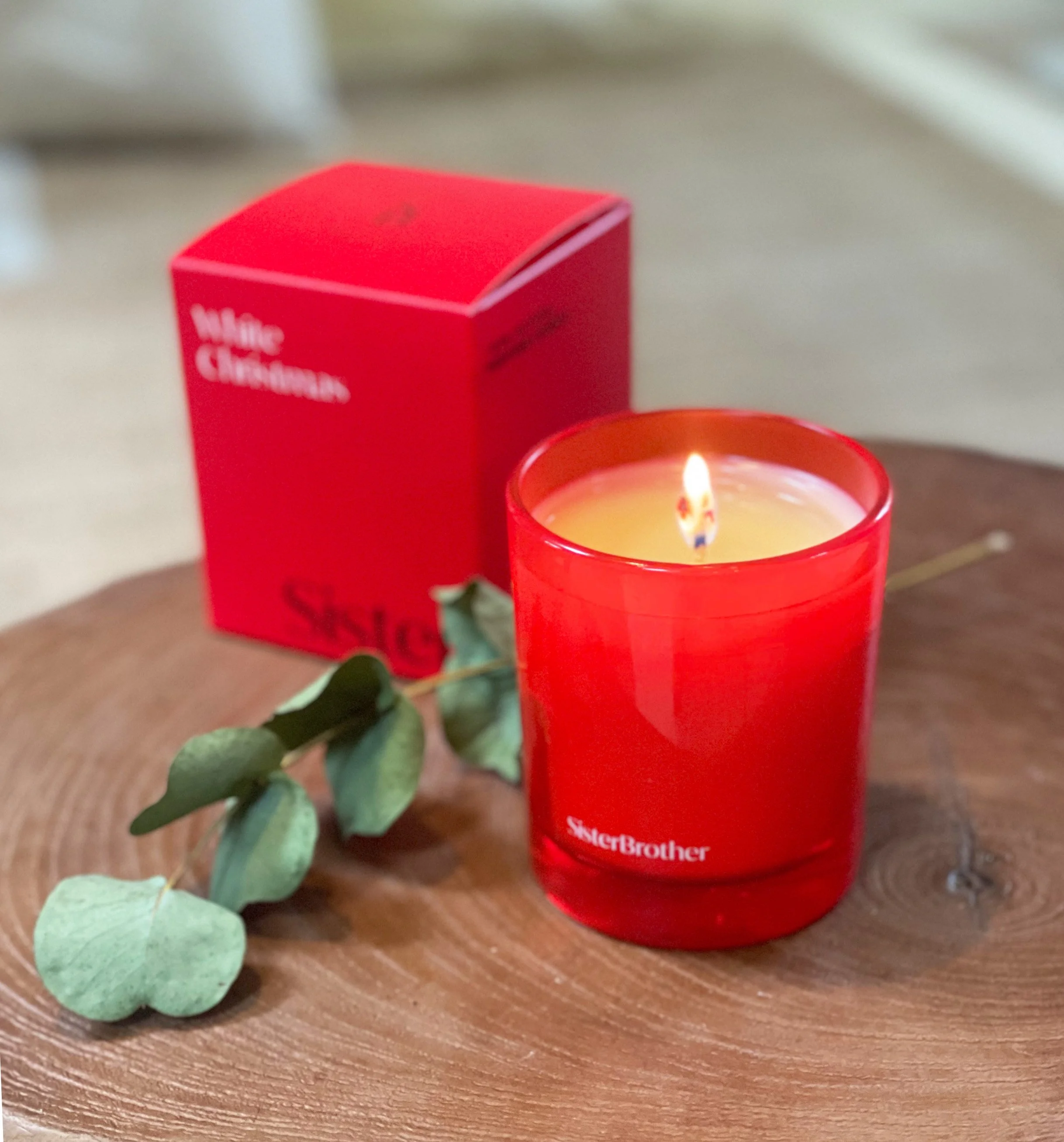 Scented candle labeled 'White Christmas' and a box of 'Sweet tea' perfume candle on a wood tray