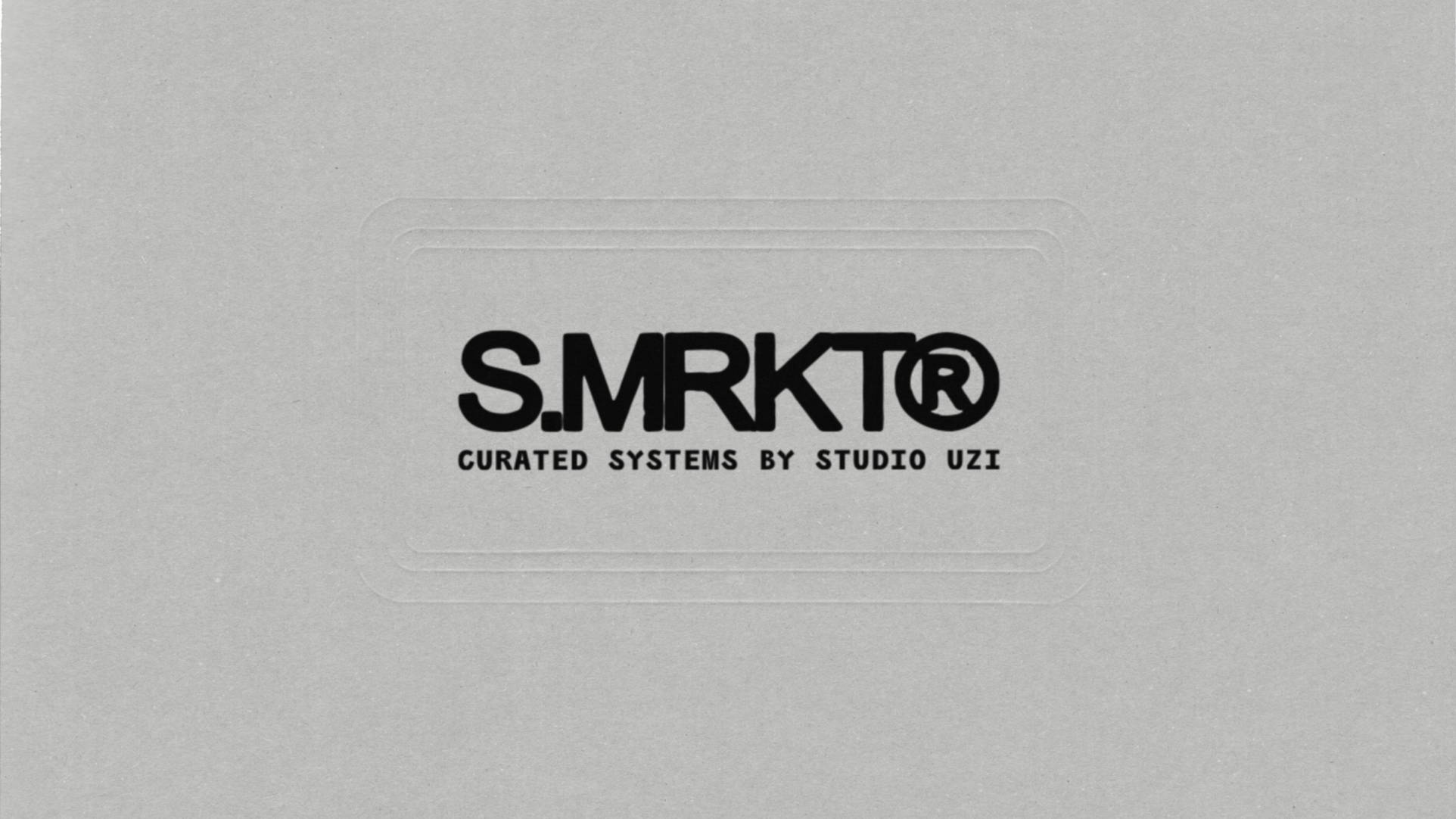 A gray surface with black text that reads 'S.MRKT® CURATED SYSTEMS BY STUDIO UZI'.