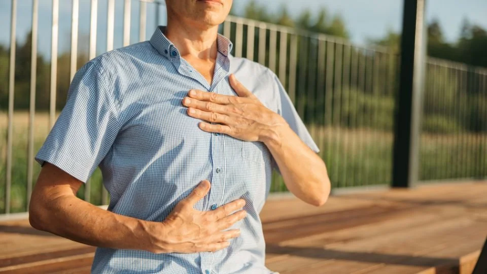 Man practising a gentle breathing exercise during spinal fusion recovery after surgery.