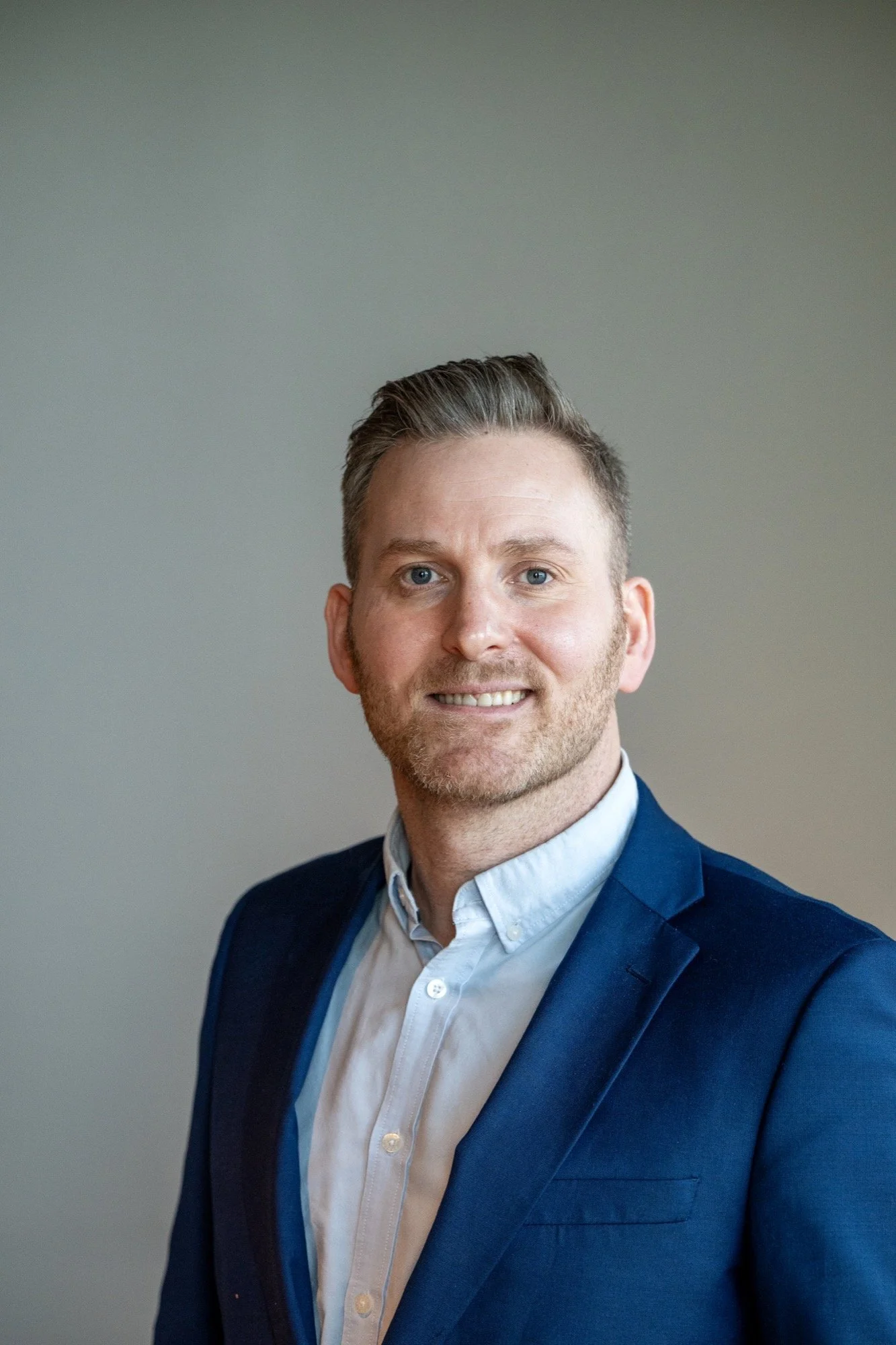 Headshot Kim Ruben Våge in a blue blazer and white shirt against a plain background.