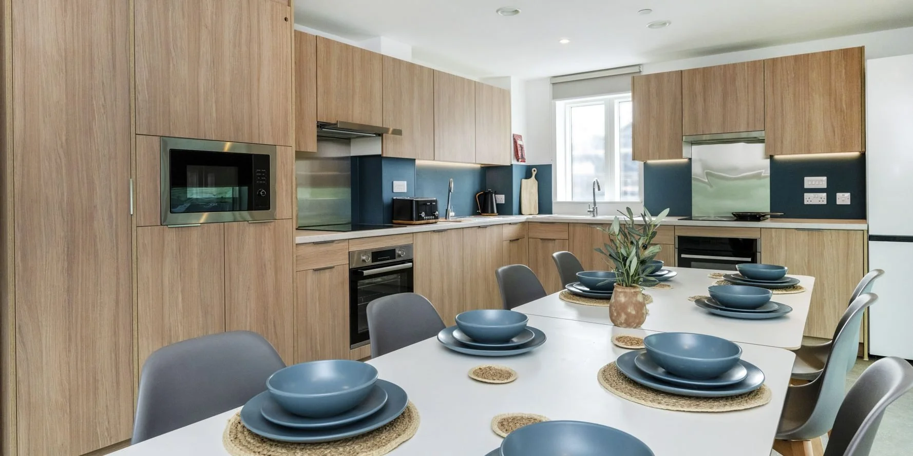 Shared kitchen and dining space at Timber Yard Bristol featuring bespoke fitted furniture designed for student living and social interaction.