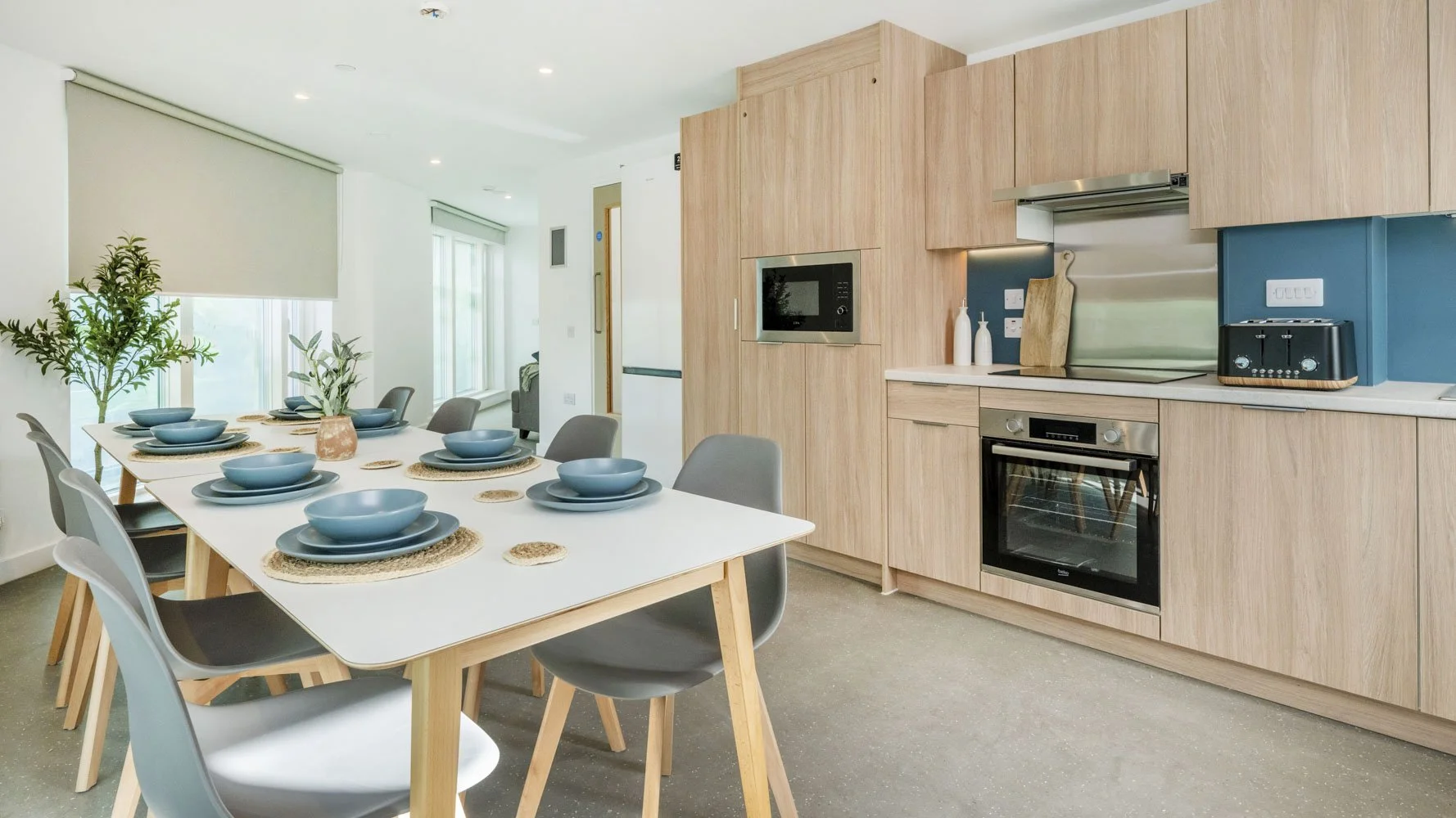 Communal kitchen and dining area at Timber Yard Bristol featuring bespoke fitted furniture designed to support shared student living.
