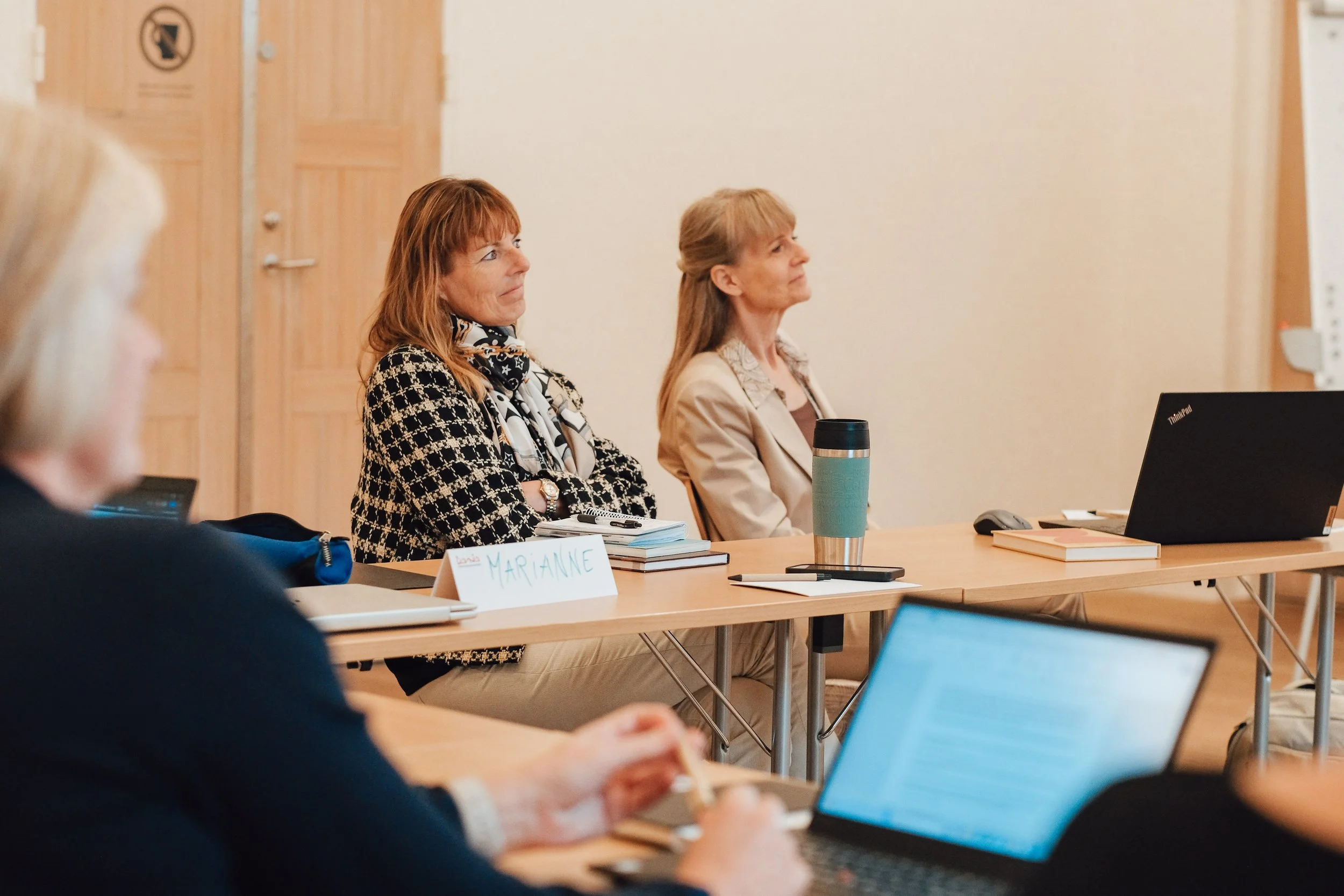 2 kvindelige deltagere på bestyrelsesuddannelse lytter til undervisningen